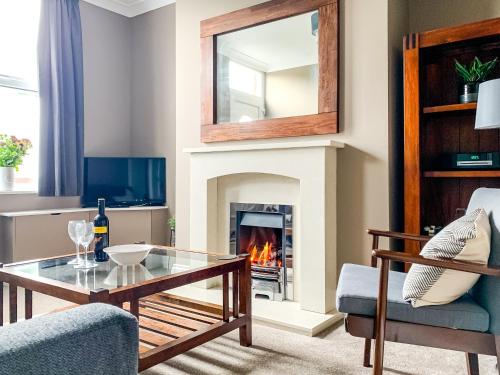 a living room with a fireplace and a glass table at Maple House - Quaint Victorian Home With Free Parking in York