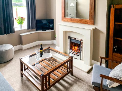 a living room with a fireplace and a glass table at Maple House - Quaint Victorian Home With Free Parking in York