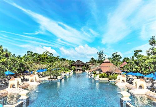 una piscina en el complejo con sillas y mesas en Seaview Resort Khao Lak - SHA Plus, en Khao Lak