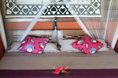 a small bed with two pillows and a canopy at Boraha Village Ecolodge in Sainte Marie