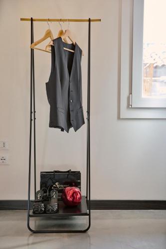 a rack with a suit and shoes and a red clock at Simone Cenedese Murano Apartments - Ambra in Venice