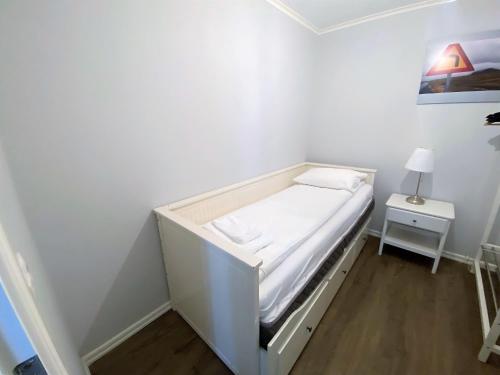 a small white room with a bed and a nightstand at Day Dream Soleyjargata Rooms & Apartments in Reykjavík