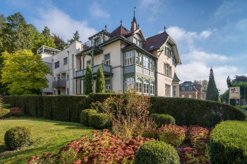 a large house with a garden in front of it at Hotel Garni Villa Rosengarten in Überlingen