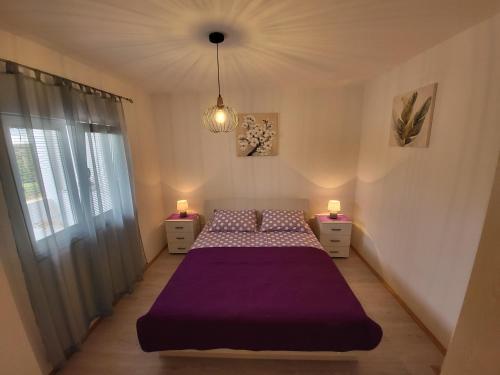 um quarto com uma cama roxa e duas mesas de cabeceira em Salkić Apartman em Fažana