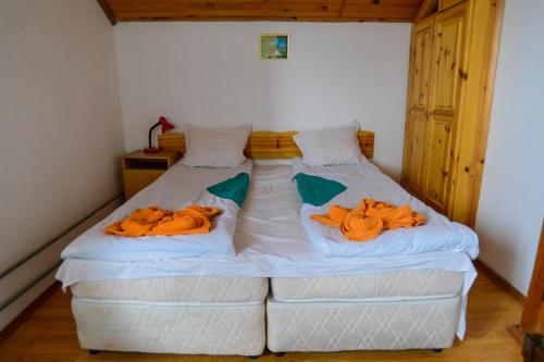 a bedroom with two beds with orange towels on them at Topuzovi Guest House in Dobrinishte