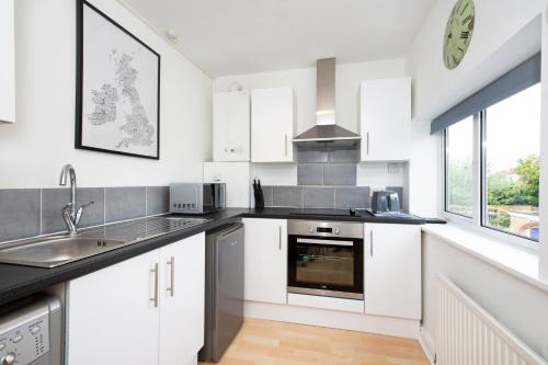 a kitchen with white cabinets and a sink at Stable Lofts in York