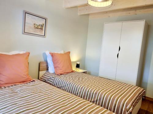 two beds sitting next to each other in a room at Fleurs de vigne, gîte charentais au grand coeur in Bouteville