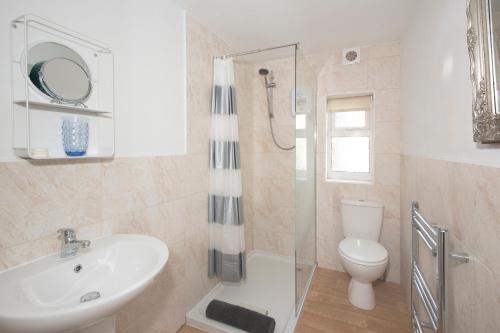 a bathroom with a sink and a toilet and a shower at Stable Lofts in York