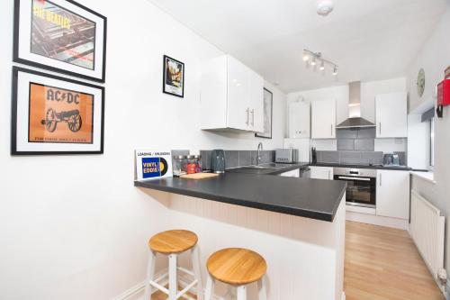 a kitchen with white cabinets and a black counter top at Stable Lofts in York