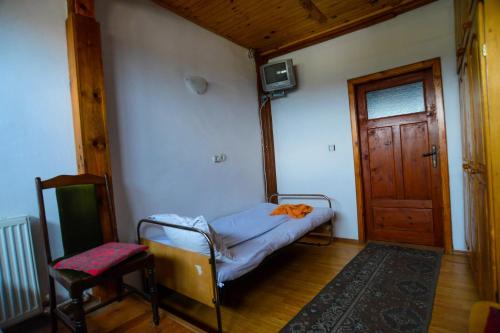 a room with a bed and a chair and a door at Topuzovi Guest House in Dobrinishte