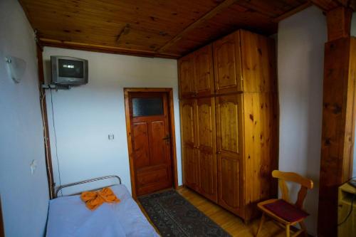 a bedroom with a bed and a cabinet and a television at Topuzovi Guest House in Dobrinishte