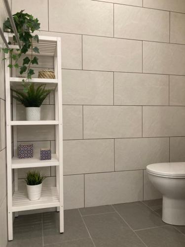 baño con una pared de azulejos blancos en Castle View Apartments, en Alicante