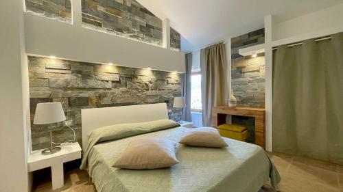 a bedroom with a bed and a stone wall at Borgo del Nespolo in Peschici