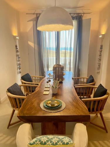 a dining room with a large wooden table and chairs at Lidia Villa in Panormos Mykonos