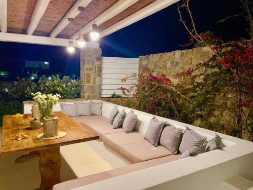 a living room with a white couch and a wooden table at Lidia Villa in Panormos Mykonos