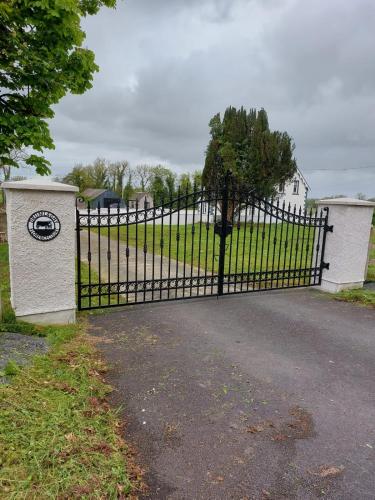 a black iron gate in front of a driveway at Drumlaghy House in Florencecourt