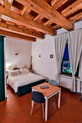a bedroom with a bed and a table and a window at Diomede Rooms - Manfredi Homes&Villas in Manfredonia