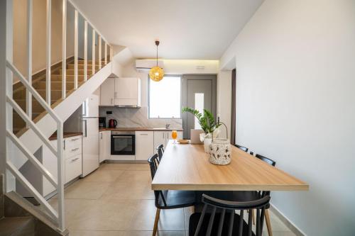 a kitchen and dining room with a wooden table and chairs at Aegean Breeze Luxury Apartments next to the sea in Maleme