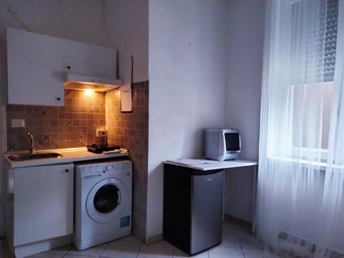 una cucina con lavatrice e microonde di MICHELANGELO 26 Monolocale a Milano