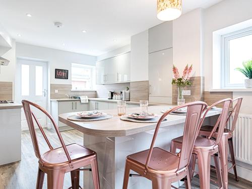 a kitchen with a table and four chairs at Pass the Keys Luxury Bright Spacious Family Home - Near Beaches in Swansea