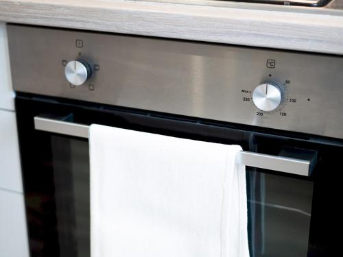 a towel hanging on the door of a stove at Pass the Keys Luxury Bright Spacious Family Home - Near Beaches in Swansea