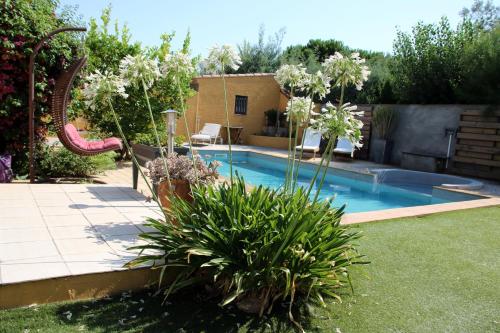 einen Pool in einem Garten mit Rutsche in der Unterkunft SUITE SPA PRIVATIF 66 Nord de Perpignan in 