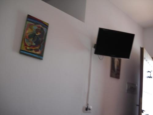 telewizor z płaskim ekranem na ścianie w pokoju w obiekcie Casa Caremy w mieście Almería