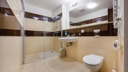 a bathroom with a toilet and a sink and a shower at Olympic Park I, Sun & Snow in Kołobrzeg