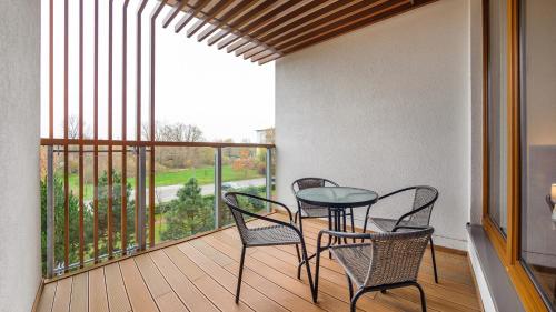 a balcony with a table and chairs and a window at Olympic Park I, Sun & Snow in Kołobrzeg