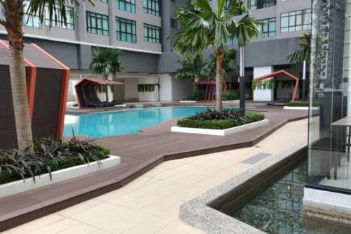 a large building with a swimming pool and palm trees at Conezion 3-bedroom condo @ IOI City Mall Putrajaya in Serdang