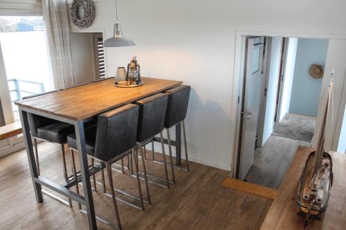 a wooden table with black chairs in a room at Luxe woonboot unieke locatie Friesland Âlde Feanen in De Veenhoop