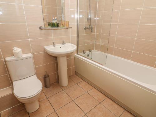 a bathroom with a toilet and a sink and a tub at Lake House Bowness in Windermere