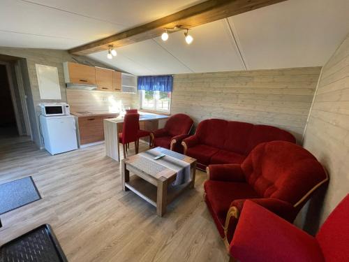 a living room with red couches and a table at Domčeky na Ranči in Sučany