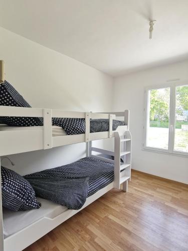 Un dormitorio con dos literas en una habitación. en Gîte de Kerninon Maison spacieuse et lumineuse, en Ploulech