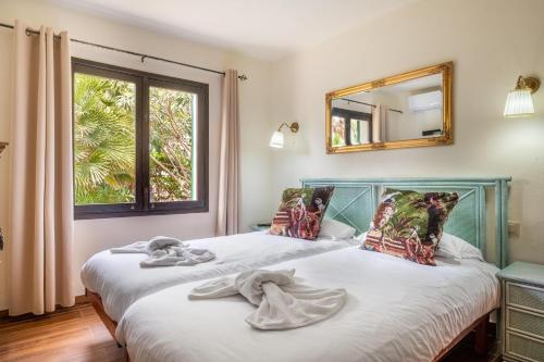two beds in a room with a mirror and a window at Casa Sol Cala dor in Cala D'or