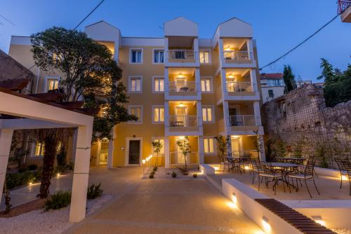 a large building with a table in front of it at PORTO SERENO apartments in Šibenik