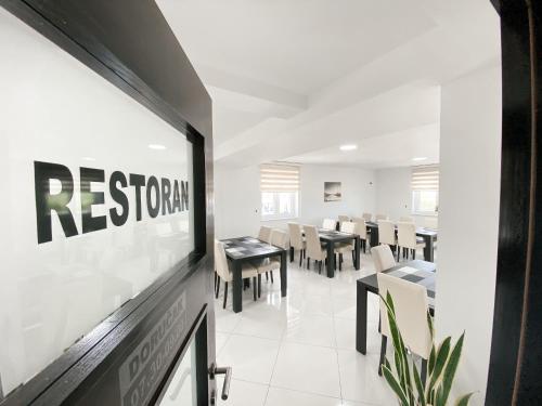 a dining room with a restaurant sign on the wall at Motel PENAVA in Posušje