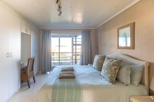 a large bed in a room with a large window at Oyster Catcher in Cape St Francis