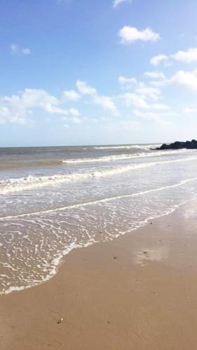 a sandy beach with waves on the ocean at Relaxing Chalet on popular California Sands short stroll to beach, nr Norfolk Broads & Great Yarmouth in Scratby