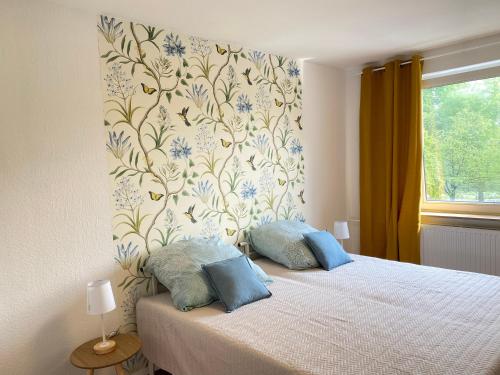 Schlafzimmer mit einem Bett mit Blumentapete in der Unterkunft SOMMER GARTEN neben Hbf Duisburg in Duisburg