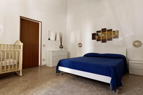 1 dormitorio con cuna y cama azul en Al Chiaro di Luna, en Marsala