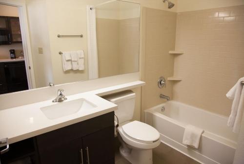 a bathroom with a sink and a toilet and a tub at Candlewood Suites Alexandria, an IHG Hotel in Alexandria