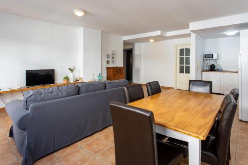 a living room with a blue couch and a wooden table at UpTown Urban Apartments in Corralejo