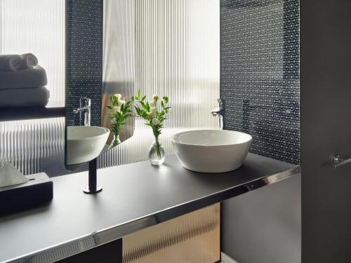 a bathroom with two sinks on a counter at Mövenpick Zagreb in Zagreb