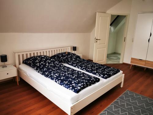 een slaapkamer met een bed met een zwart-wit dekbed bij Weller's Ferienhaus in Klingenmünster in Klingenmünster