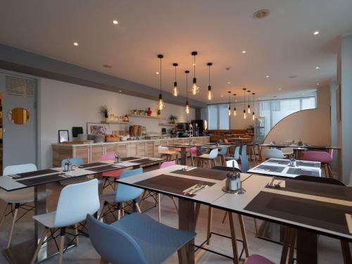 a restaurant with tables and chairs and a kitchen at Hotel Best Western City Centre in Brussels