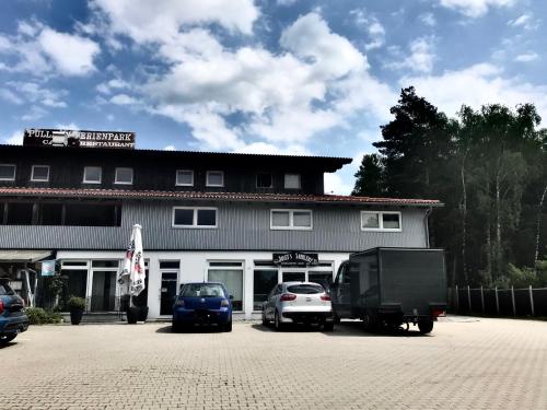 a building with cars parked in a parking lot at Classik Western Apartment Rusty in Eging am See