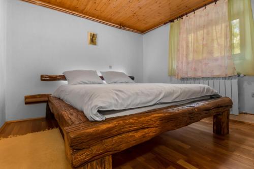 a bedroom with a wooden bed in a room with a window at Vila Tea in Novi Vinodolski