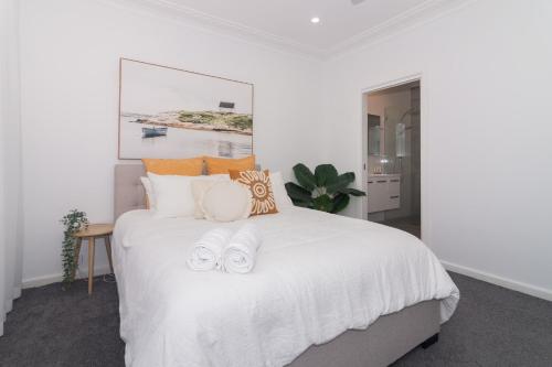 Un dormitorio con una cama blanca con toallas. en The Riverview, en North Haven