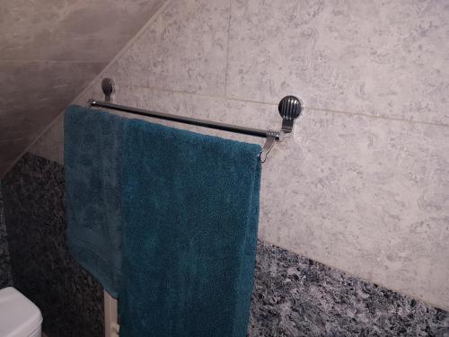 a bathroom with a blue towel hanging on a towel rack at ECO guest house in Berd